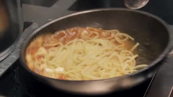 Restaurace vaření - kuchař vaří těstoviny se slaninou na pánvi — Stock video