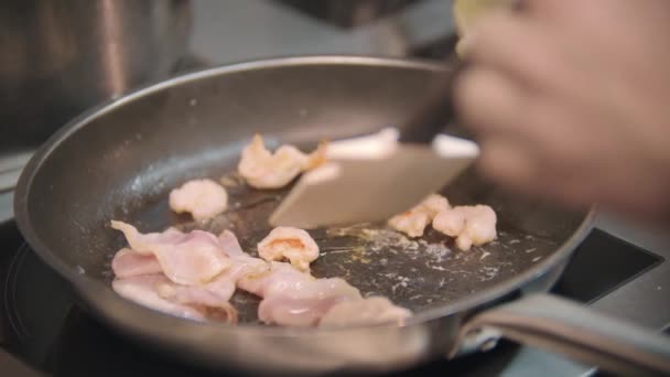 Restaurant cooking - chef roasts bacon pieces in a frying pan — Stock Video