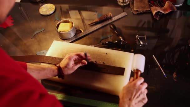The Tailor makes potholes in a piece of leather — Stock Video