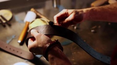 Bir adam deri kemer için boşluk çizer.