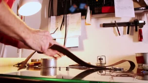 Ο ράφτης κόβει την άκρη ενός κομματιού δέρματος πριν το φτιάξει σε ζώνη — Αρχείο Βίντεο