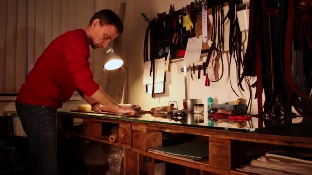 パーソナルワークショップ-男はワックスで革の一片を磨く — ストック動画