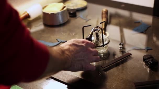 Lederwerkstatt - ein Mann erhitzt das Lötzinn am Brenner — Stockvideo
