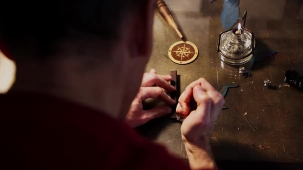 Кожаная мастерская - мужчина режет кусок кожи горячей пайкой — стоковое видео
