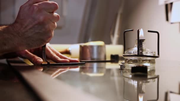 Un homme coupe le morceau de cuir pressé avec une soudure chaude avec un dispositif de chauffage au premier plan — Video