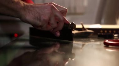 Deri atölyesi - bir adam zımpara kağıdıyla kemerin kenarlarını ovar