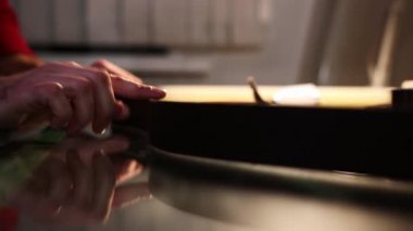 Atölyede çalışan bir adam. Deri kemerin kenarlarına mum süren bir adam.