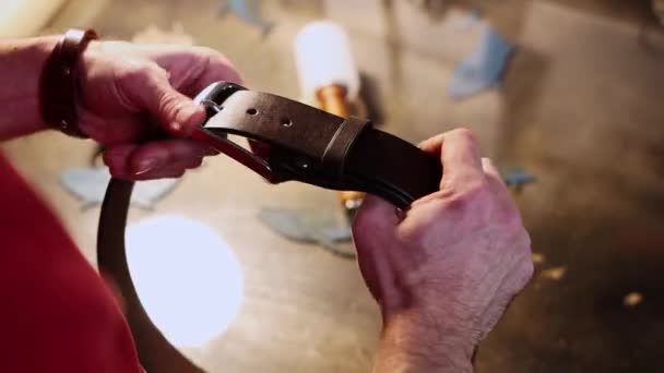 Atelier de cuir - un homme termine la fabrication d'une ceinture en cuir — Video