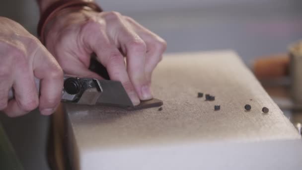 En mand skærer et lille stykke læder af bæltet – Stock-video