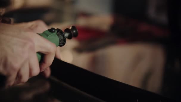 A man in his workshop polishes edges of a belt using a grinder — Stock Video