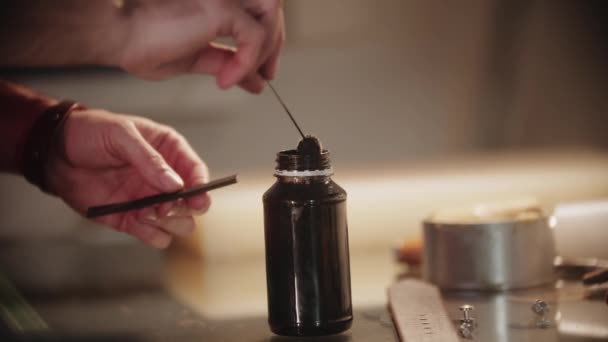 Krejčí zpracovává okraje malého kusu kůže speciálním roztokem pomocí měkkého nástroje — Stock video