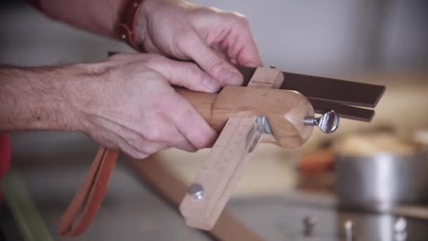 Skrædderen skærer et stykke læder ved hjælp af et instrument – Stock-video