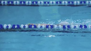 25-15-2021 RUSSIA, KAZAN - YÜKSEK KONUŞUYOR - bir çocuk bacaklarını kullanarak pistte sırt üstü yüzüyor