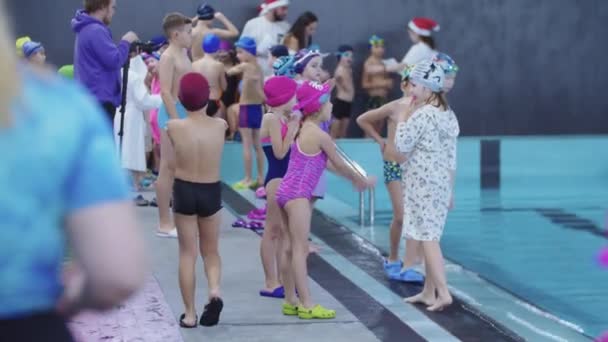 25-15-2021 RUSSIE, KAZAN - COMPÉTITIONS DE NAGES - une foule de jeunes enfants se tient près de la piscine — Video