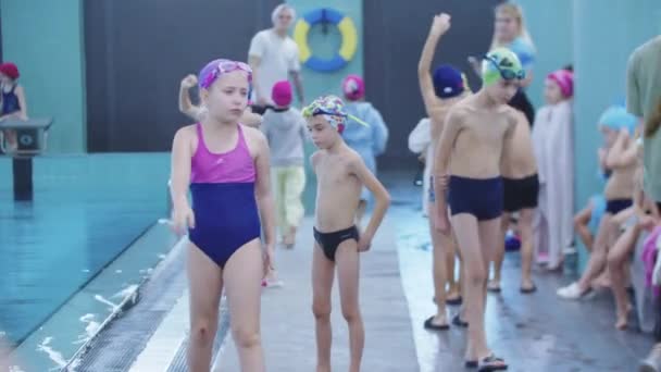 25-15-2021 RUSIA, KAZAN - COMPETICIONES DE Nadar - niños pequeños caminando y descansando junto a la piscina — Vídeos de Stock
