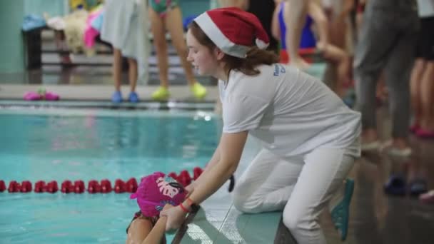25-15-2021ロシア, KAZAN -水泳大会-コーチは女の子が水から出るのを助ける — ストック動画
