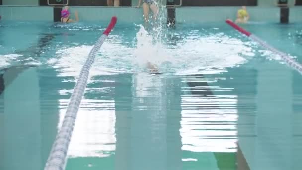 COMPETICIONES DE Nadar: un niño pequeño nadando boca arriba usando sus piernas — Vídeos de Stock
