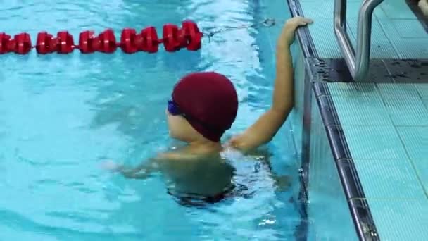 25-15-2021 RUSSIA, KAZAN - SWIMMING COMPETITIONS - a little boy waits for the signal hanging by the sideboard — Stock Video