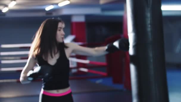 Mujer joven entrenando boxeo luego camina hacia una cámara y muestra sus guantes de boxeo — Vídeo de stock