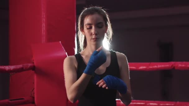 Young woman bandaging her hands with elastic bandages before boxing training — Stock Video