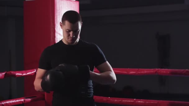 Ein junger Mann zieht seine Boxhandschuhe an — Stockvideo