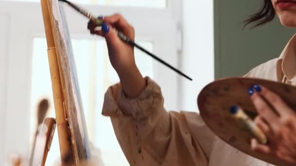 Estudio de arte mujer artista en camisa manchada de color blanco dibujo de una pintura — Vídeos de Stock