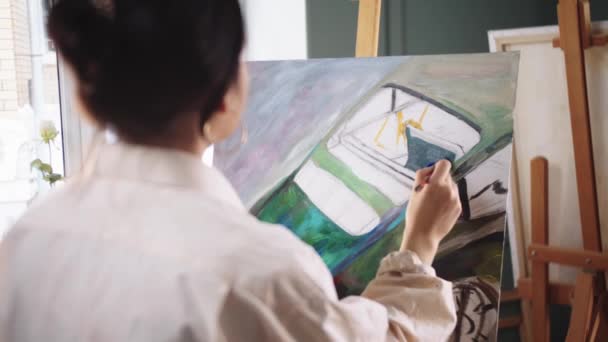 Egy női művész autót fest a vászonra. — Stock videók