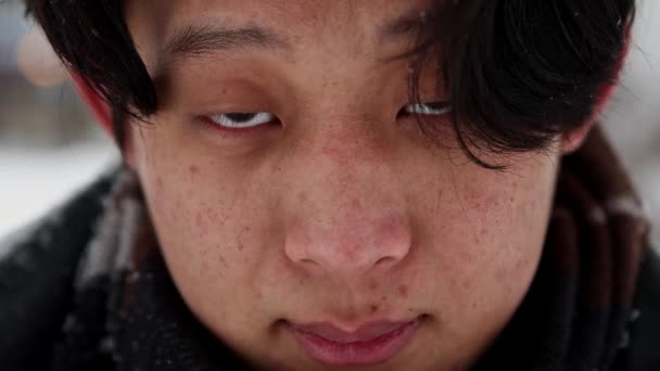 Mladý asijský muž zvedne hlavu a podívá se do kamery — Stock video