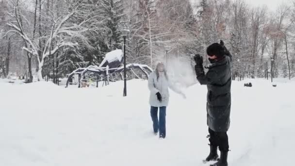 Jovem asiático homem jogar bolas de neve com sua mulher negra amigo — Vídeo de Stock