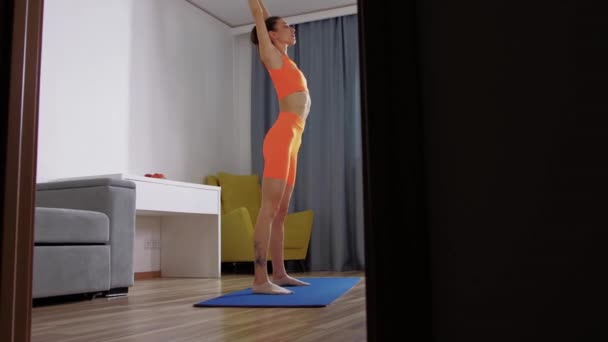 Fitness em casa - jovem mulher esticando seu corpo na sala — Vídeo de Stock