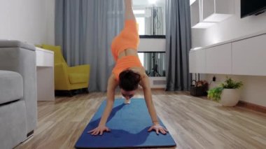 Evde spor yapmak - Yoga minderinde spor yapan genç bir kadın