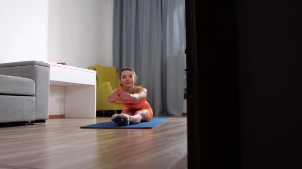 Фитнес дома - молодая женщина, занимающаяся фитнесом в номере — стоковое видео