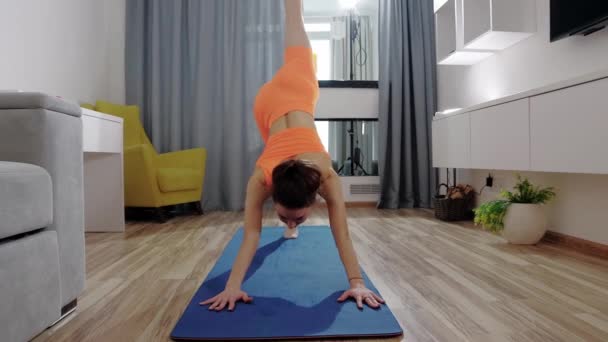 Fitness en casa - mujer joven haciendo ejercicios de fitness en la esterilla de yoga — Vídeos de Stock