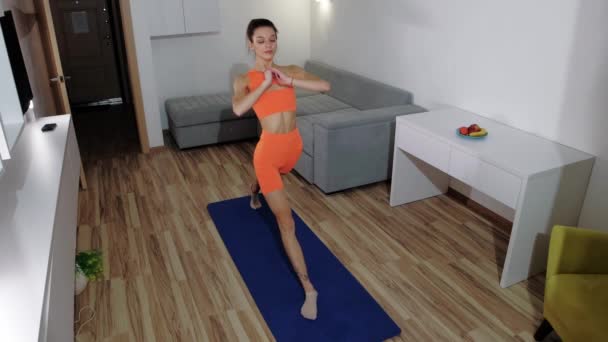 Фітнес вдома - молода струнка жінка робить фізичні вправи на йога килимок — стокове відео