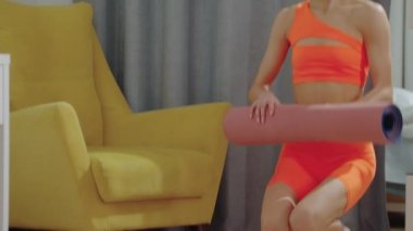 Genç bir kadın odaya yoga minderi serdi.