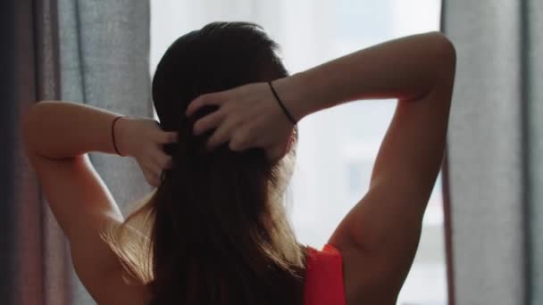 Молодая спортсменка, готовая заплести волосы в хвостик. — стоковое видео