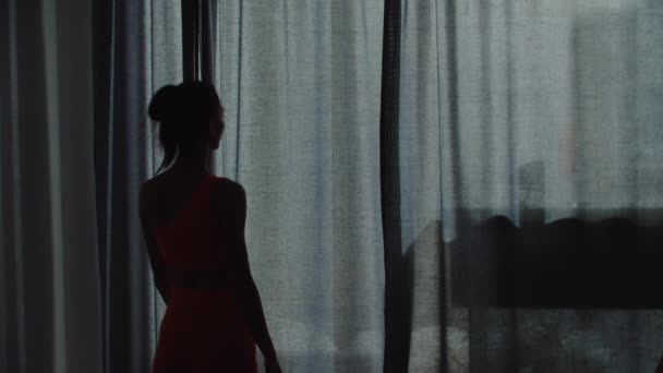Jeune femme silim en vêtements de sport ouvre les rideaux et laisse la lumière dans la pièce — Video
