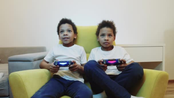 Zwei kleine schwarze Jungen Brüder spielen ein Spiel mit Joysticks — Stockvideo