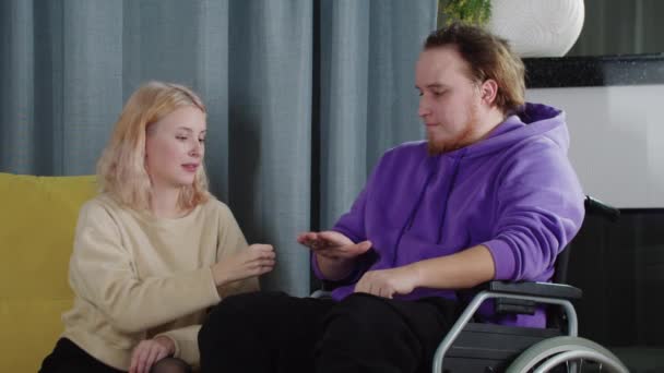 Szczęśliwa para blondyn i mężczyzn na wózku inwalidzkim grających w kamień-papier-nożyczki — Wideo stockowe