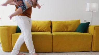 Aile kanepeye oturur ve kucağına bebek alır.
