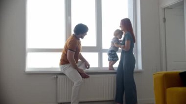 Küçük oğlu pencere kenarında mutlu bir aile.