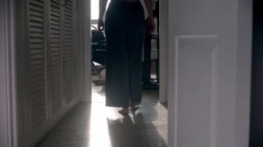 Anne kocasına ve küçük bebeğine doğru yürür ve onlara sarılır.