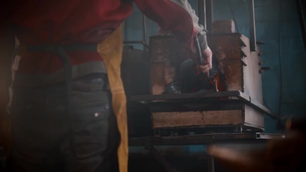 ब्लॅक्समिथ कार्यशाळा एक माणूस ओव्हनमध्ये धातूची वस्तू ठेवतो — स्टॉक व्हिडिओ