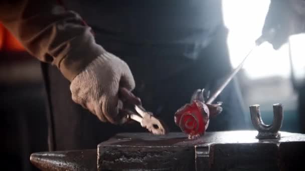 Blacksmith workshop - a man shaping a rose out of heated metal — ストック動画