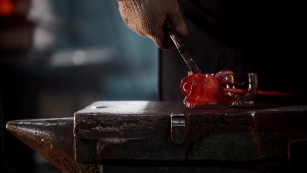 Smedja workshop - en man som formar ros löv av uppvärmd metall med hjälp av pincett — Stockvideo