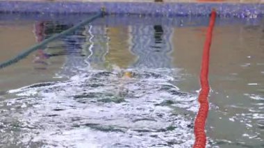 Havuzda pistte yüzen bir adam.