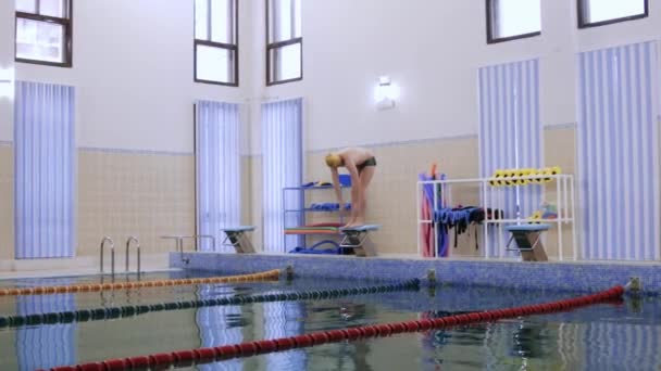 Instructor de natación saltando en el agua desde el stand — Vídeo de stock
