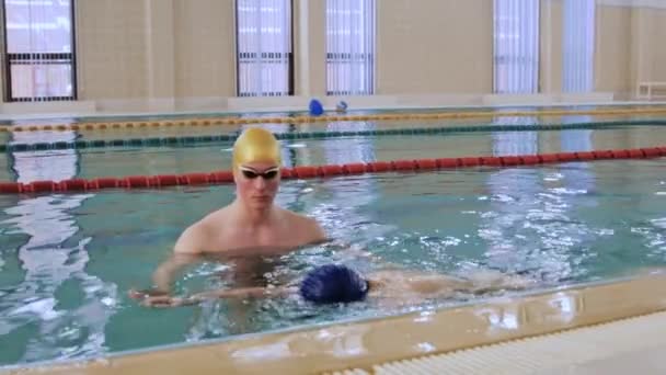 Εκπαιδευτής κολύμβησης που μαθαίνει κολύμπι στην πισίνα — Αρχείο Βίντεο