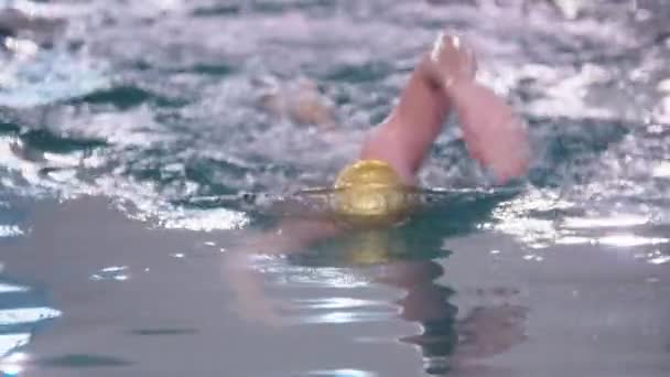 Seorang pria dengan topi berwarna emas berenang di trek di kolam renang — Stok Video