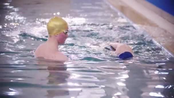 RUSSIA KAZAN 30-01-2022: Zweminstructeur die een kind leert zwemmen in het zwembad — Stockvideo